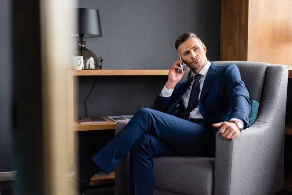 Enfoque selectivo de hombre de negocios en traje hablando en el teléfono inteligente - foto de stock