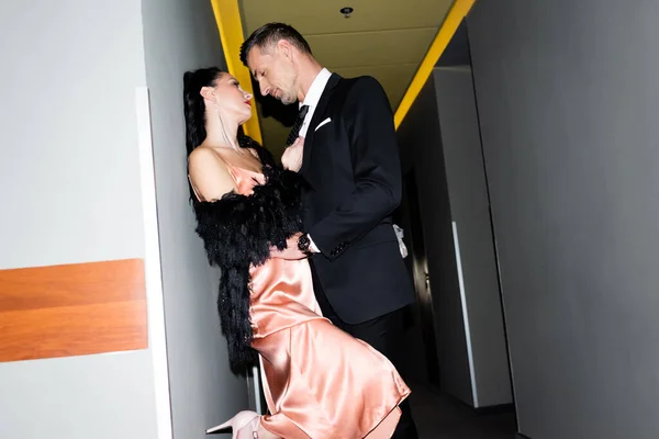 Vista laterale di fidanzato e fidanzata baciare e abbracciare in hotel — Foto stock