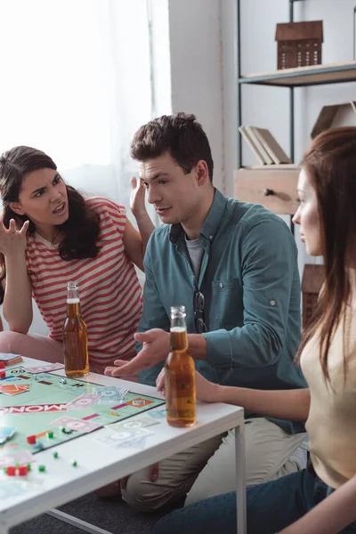 KYIV, UKRAINE - JANUARY 27, 2020: angry girl gesturing near confused man while playing monopoly game — Stock Photo