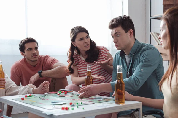 KYIV, UKRAINE - JANUARY 27, 2020: angry girls gesturing near confused man while playing monopoly game — Stock Photo