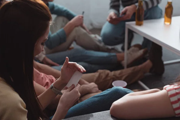 Молодая женщина держит пустую карту, сидя рядом с друзьями — стоковое фото