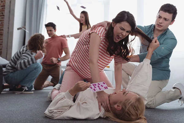 KYIV, UKRAINE - JANUARY 27, 2020: angry friends quarreling and fighting while holding and throwing lotto cards — Stock Photo