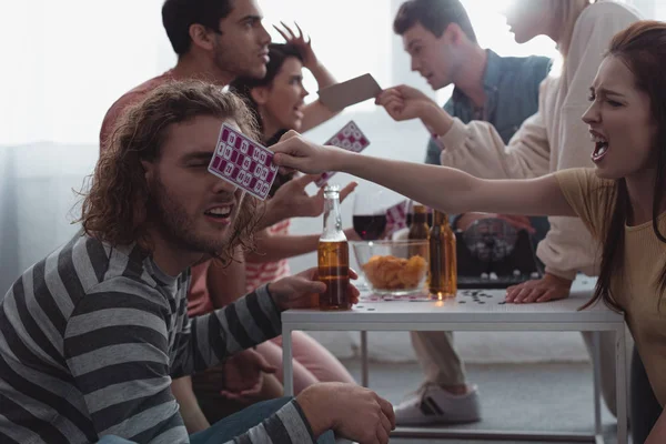 KYIV, UKRAINE - JANUARY 27, 2020: aggressive friends quarreling and screaming while holding lotto cards — Stock Photo