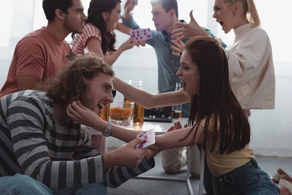 KYIV, UKRAINE - JANUARY 27, 2020: aggressive friends quarreling and fighting while holding lotto cards — Stock Photo