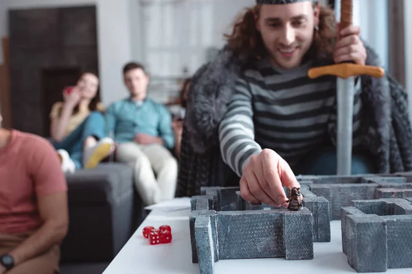 Kiew, Ukraine - 27. Januar 2020: selektiver Fokus eines lächelnden Mannes im Kostüm eines Königs beim Labyrinthspiel mit Freunden im Hintergrund — Stockfoto