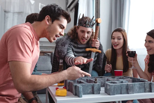 KYIV, UKRAINE - JANUARY 27, 2020: man in costume of king playing labyrinth game with friends — Stock Photo