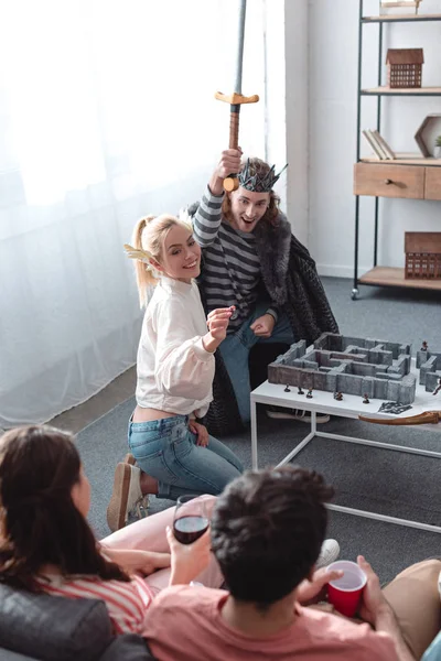 KYIV, UKRAINE - JANUARY 27, 2020: high angle view of man and woman in fairy costumes playing labyrinth game near friends — Stock Photo