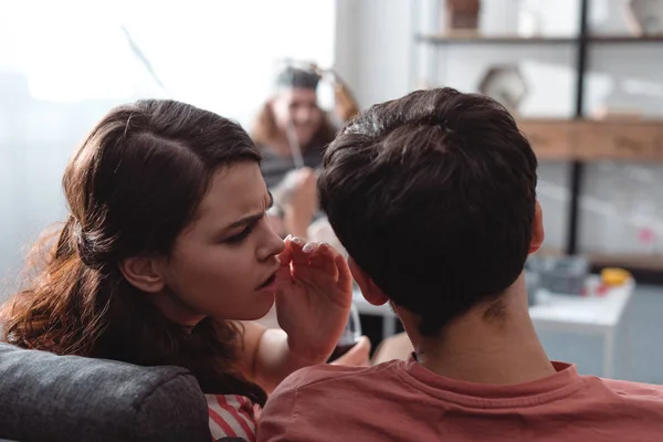 Selective focus of man in king costume near girl whispering to friend — Stock Photo