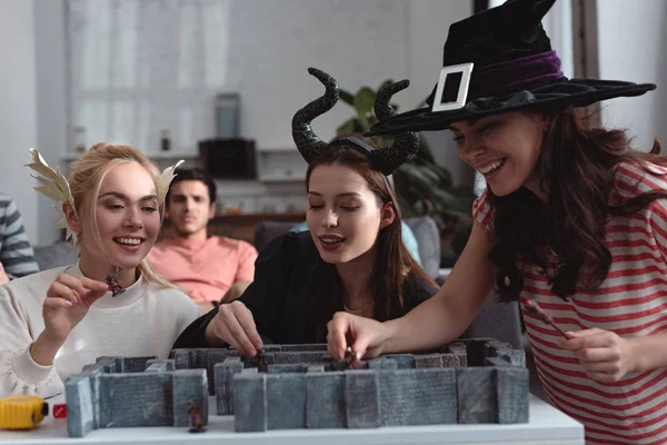KYIV, UCRAINA - 27 GENNAIO 2020: ragazze felici in costumi da fata che giocano al labirinto gioco da tavolo vicino agli amici — Foto stock