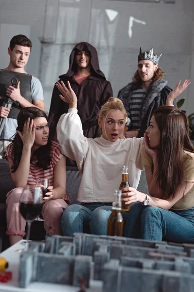 KYIV, UKRAINE - JANUARY 27, 2020: selective focus of excited girls talking near labyrinth board game while men in fairy costumes standing on background — Stock Photo