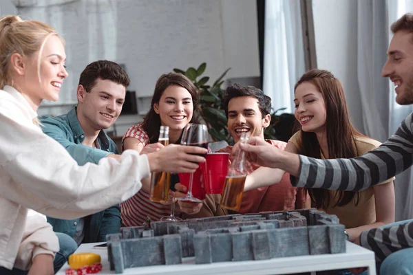 QUIIV, UCRÂNIA - JANEIRO 27, 2020: amigos felizes batendo com cerveja e vinho acima do labirinto jogo de tabuleiro — Fotografia de Stock