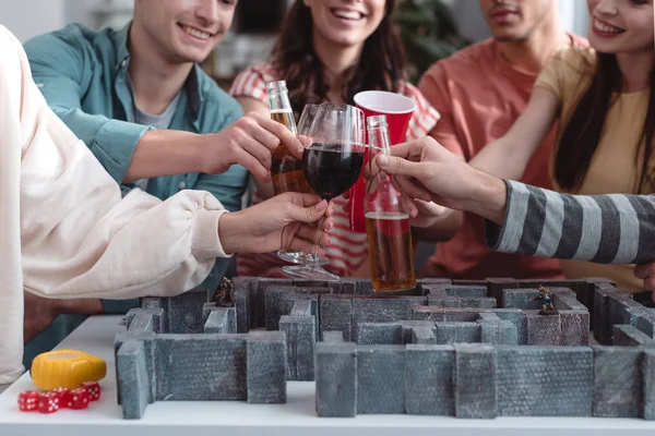 KYIV, UKRAINE - JANUARY 27, 2020: cropped view of cheerful friends with beer and wine near labyrinth game — Stock Photo