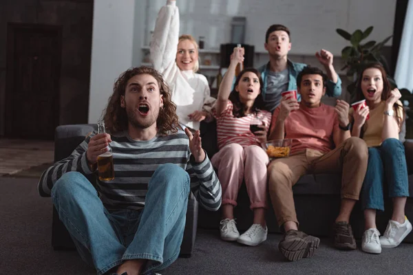 Amigos animados mostrando gesto vencedor enquanto assiste campeonato em casa — Fotografia de Stock