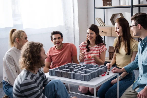 KYIV, UKRAINE - JANUARY 27, 2020: young smiling friends playing labyrinth game at home — Stock Photo