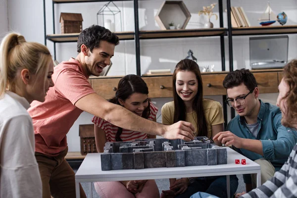 KYIV, UKRAINE - JANUARY 27, 2020: cheerful young friends playing labyrinth board game at home — Stock Photo