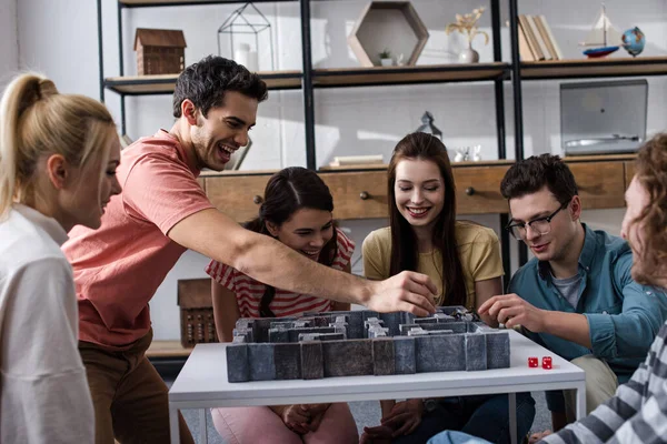 KYIV, UKRAINE - 27 JANVIER 2020 : joyeux jeunes amis jouant au jeu de plateau labyrinthe à la maison — Photo de stock