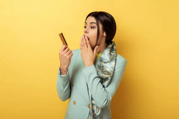 Menina americana africana surpreso olhando para o cartão de crédito no amarelo — Fotografia de Stock