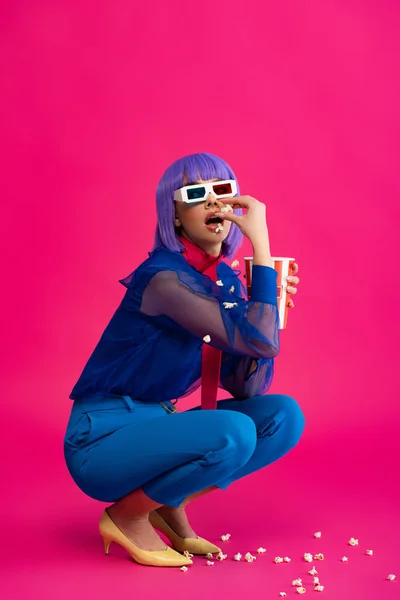 Hermosa chica de arte pop en peluca púrpura y gafas 3d comer palomitas de maíz, en rosa - foto de stock