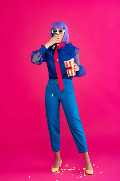 Fashionable pop art girl in purple wig and 3d glasses eating popcorn, on pink — Stock Photo