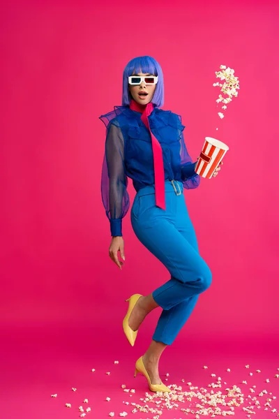 Sorpresa pop art ragazza in parrucca viola e occhiali 3d gettando popcorn, su rosa — Foto stock