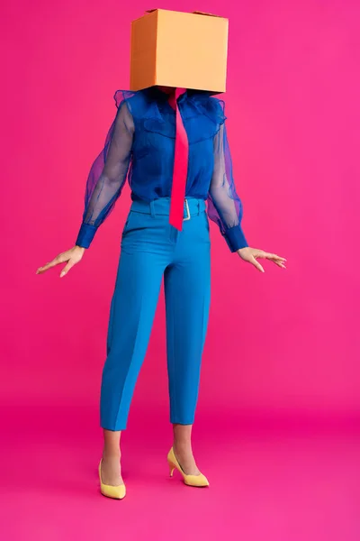 Fashionable girl with cardboard box on head on pink — Stock Photo