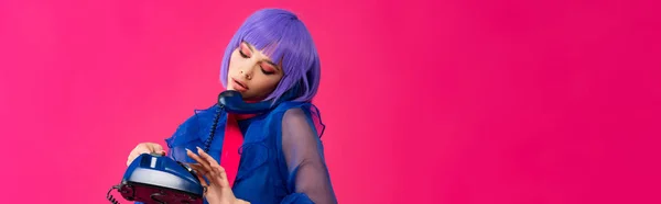 Panoramic shot of beautiful trendy girl in purple wig talking on retro phone, isolated on pink — Stock Photo