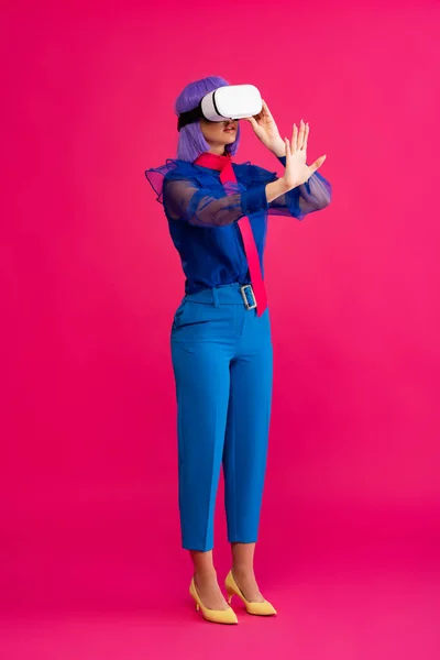 Поп-арт дівчина в синій модній блузці з використанням гарнітури віртуальної реальності, на рожевому — стокове фото