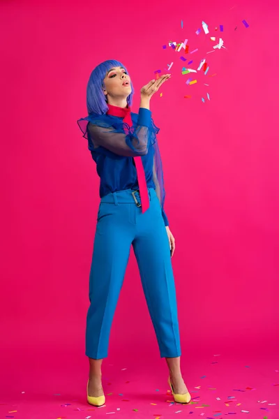 Bella ragazza pop art in parrucca viola soffiando corietti, su rosa — Foto stock