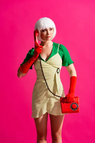 Beautiful pop art girl in white wig talking on retro telephone, isolated on pink — Stock Photo