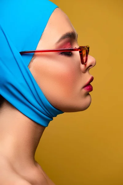 Atractiva chica de moda en bufanda de moda y gafas de sol rojas, aislado en amarillo - foto de stock