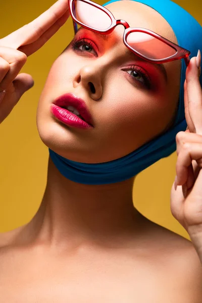 Beau modèle à la mode en écharpe tendance et lunettes de soleil rouges, isolé sur jaune — Photo de stock