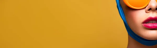 Colpo panoramico di donna sexy in sciarpa e occhiali da sole arancione alla moda, isolato su giallo — Foto stock