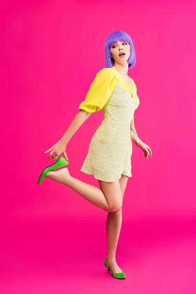 Привлекательная девушка поп-арта в фиолетовом парике и желтом платье позирует на розовом — стоковое фото