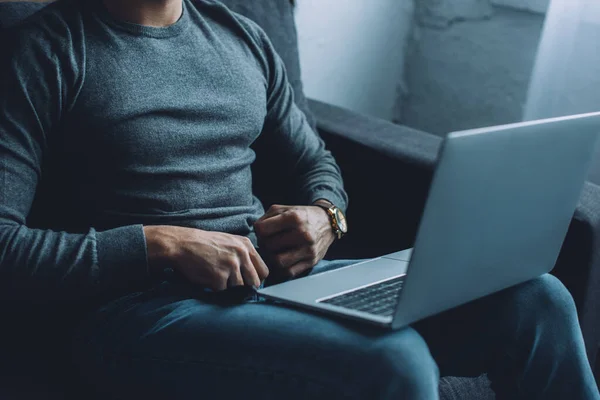 Обрізаний вид чоловіка, який розблоковує джинси під час перегляду порнографії на ноутбуці на дивані — стокове фото