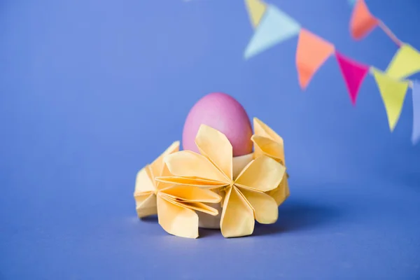 Foco selectivo de flores de origami cerca de huevo de Pascua en azul - foto de stock