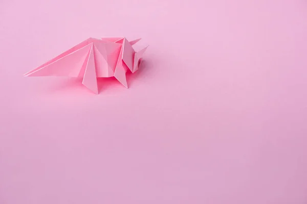 Decorative origami rhinoceros on pink with copy space — Stock Photo