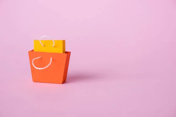 Small shopping bags on pink with copy space — Stock Photo