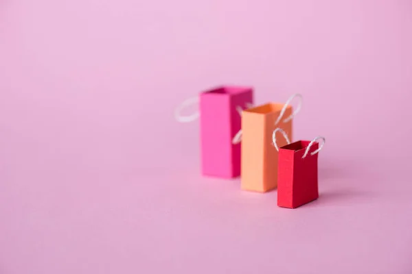 Selective focus of small shopping bags on pink with copy space — Stock Photo