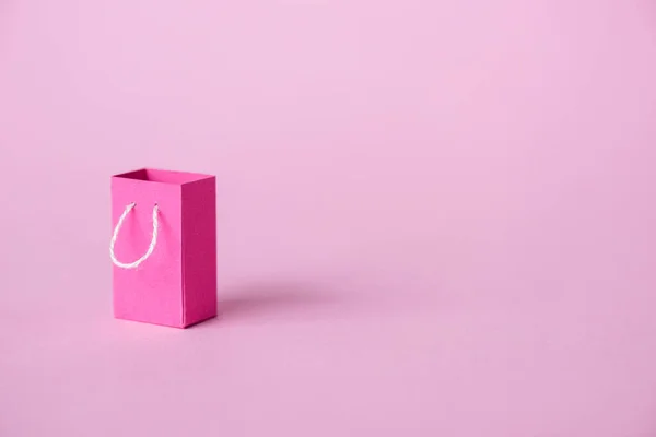Small shopping bag on pink with copy space — Stock Photo
