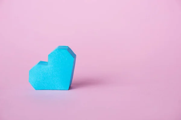 Blue origami heart on pink with copy space — Stock Photo