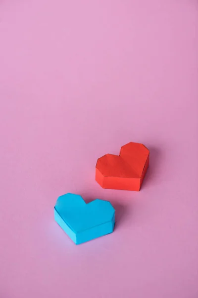 Синьо-червоні серця орігамі на рожевому з простором для копіювання — стокове фото