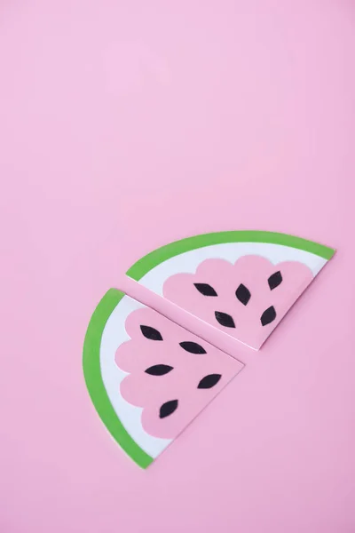 Нарізаний паперовий кавун з чорним насінням ізольовано на рожевому — стокове фото