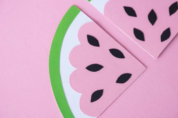 Vista superior de la sandía de papel en rodajas con semillas negras aisladas en rosa - foto de stock