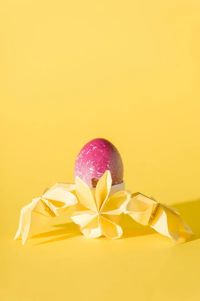 Paper flowers near painted easter egg on yellow with copy space — Stock Photo