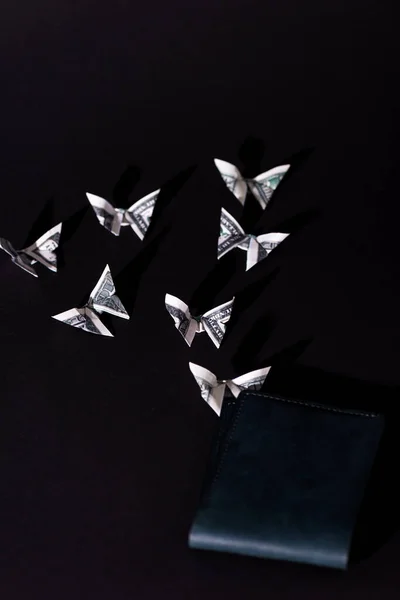 Decorative money origami butterflies near wallet isolated on black — Stock Photo