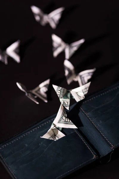 Вибірковий фокус грошей орігамі метелики біля гаманця ізольовані на чорному — стокове фото