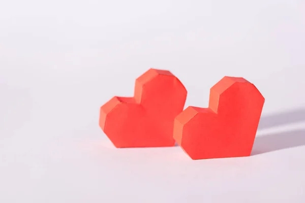 Red origami hearts on white with copy space — Stock Photo