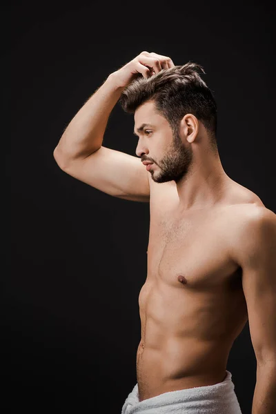 Сексуальный красивый мужчина в полотенце расчесывая волосы изолированы на черный — стоковое фото