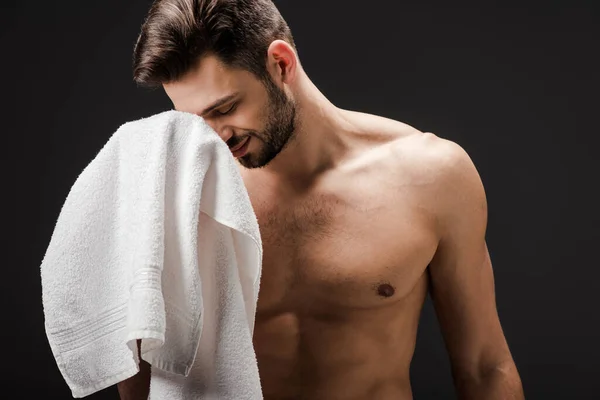 Happy handsome naked man with towel isolated on black — Stock Photo