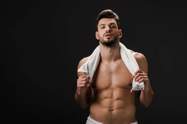 Handsome man with towel isolated on black — Stock Photo